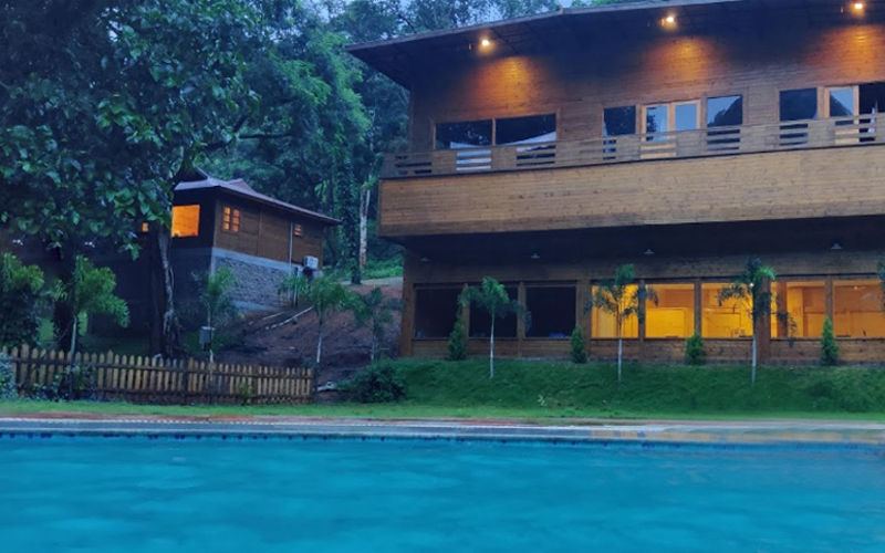 Swimming pool and main block at The Woods Resort Maredumilli at dusk