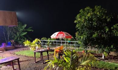 Garden seating with umbrella at Sana Resort Maredumilli at night